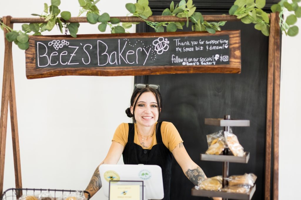 The owner of Beez's Bakery smiling behind her booth at the Berlin Grand Opening.